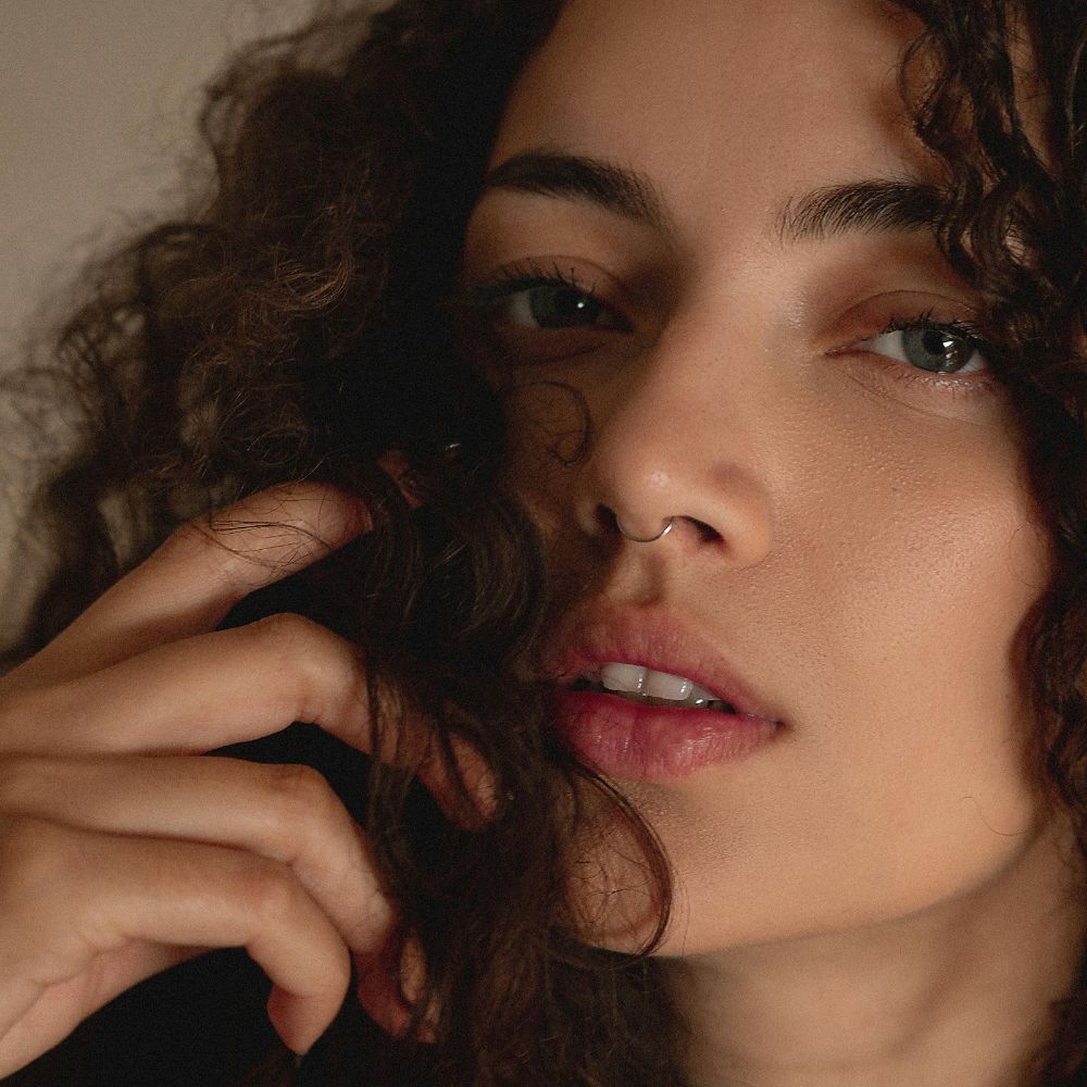 Femme avec cheveux bouclés brillants et définis naturellement
